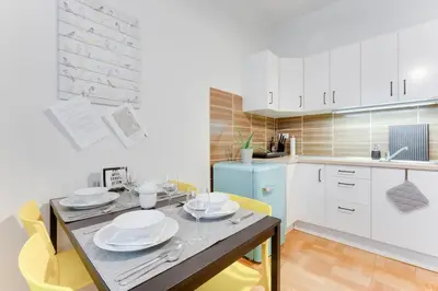 a kitchen with a dining table and yellow chairs at Apartment Alex in Prague