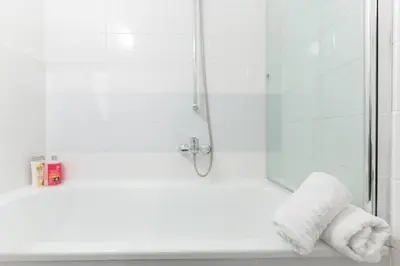 a shower with a glass door and two towels at Apartment Alex in Prague