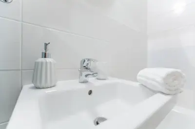 a bathroom sink with a towel and a soap dispenser at Apartment Alex in Prague