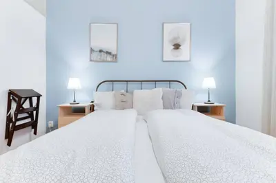 a bedroom with a large white bed with two lamps at Apartment Alex in Prague