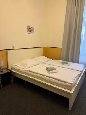 a room with two beds and a bathroom with a shower at Welcome Hostel & Apartments Praguecentre in Prague