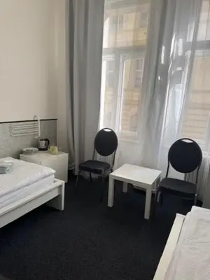 a bedroom with two chairs and a table and a bed at Welcome Hostel & Apartments Praguecentre in Prague