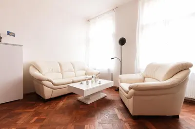a living room with two white chairs and a coffee table at Prague Days - Spacious Retro-vibes Apartment near Charles Square in Prague