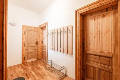 a hallway with a wooden door and a staircase at Prague Days - Spacious Retro-vibes Apartment near Charles Square in Prague