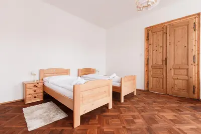 a bedroom with two beds and a wooden cabinet at Prague Days - Spacious Retro-vibes Apartment near Charles Square in Prague