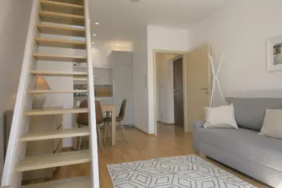 a living room with a staircase and a couch at Prague Expat House in Prague