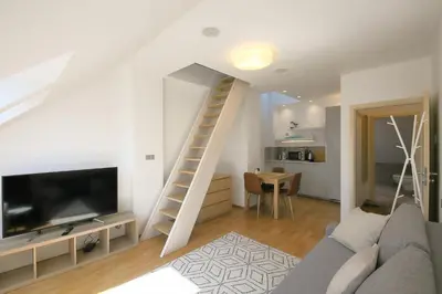 a living room with a couch and a staircase at Prague Expat House in Prague