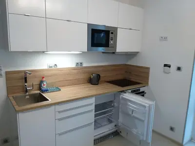 a kitchen with white cabinets and a sink and a microwave at Garden studio apt-FREE parking,close D8,metro,EXPO in Hovorčovice