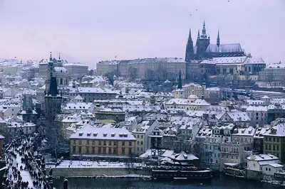 a city with snow covered buildings and a castle at Garden studio apt-FREE parking,close D8,metro,EXPO in Hovorčovice