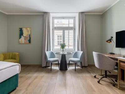 a bedroom with a bed and a desk with a laptop at Numa Prague Libusa in Prague