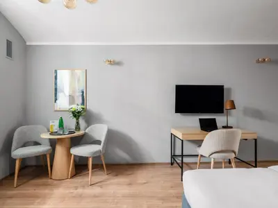 a bedroom with a bed with a green headboard and a desk at Numa Prague Libusa in Prague