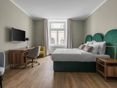 a bed with two pillows and a green headboard at Numa Prague Libusa in Prague