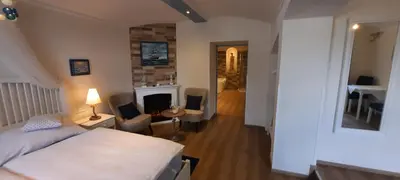 a bedroom with a bed and a living room with a fireplace at Excellent Romantic in Prague