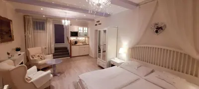 a bedroom with a white bed and a chair and a table at Excellent Romantic in Prague