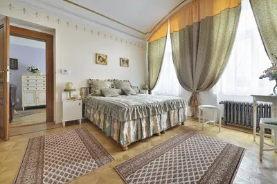 a bedroom with a bed and a large window at Apartman Dalia Janáčkovo nábřeží in Prague