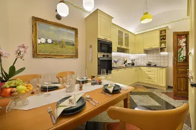 a kitchen with a wooden table and a dining room at Apartman Dalia Janáčkovo nábřeží in Prague