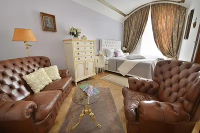 a living room with two leather chairs and a bed at Apartman Dalia Janáčkovo nábřeží in Prague