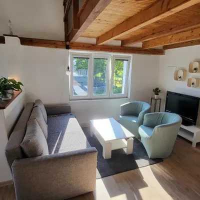 a living room with a couch and two red chairs at Apartmán ,,Rokytka