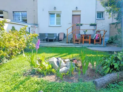 a garden with a table and chairs on a house at Duplex with garden in Prague