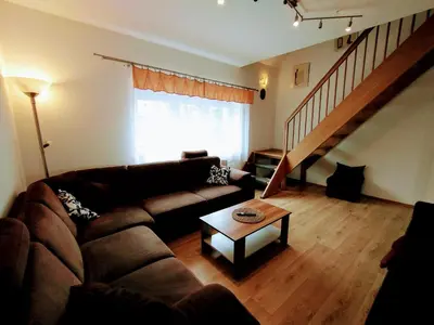 a living room with a couch and a table at Duplex with garden in Prague