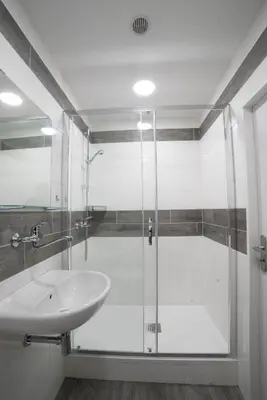 a bathroom with a glass shower and a sink at Apartments Katarina in Prague