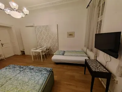 a room with two beds and a flat screen tv at Apartments Katarina in Prague