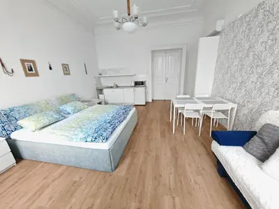 a bedroom with a bed and a table and a couch at Apartments Katarina in Prague