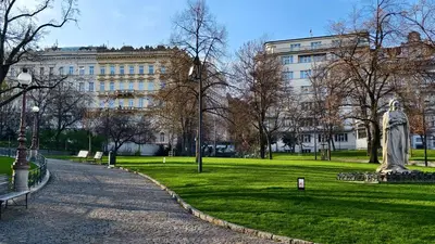 a statue in a park in front of a building at Apartments Katarina in Prague
