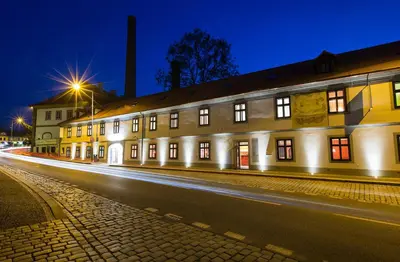 a lit up building on a street at night at Hotel Restaurant Darwin in Prague