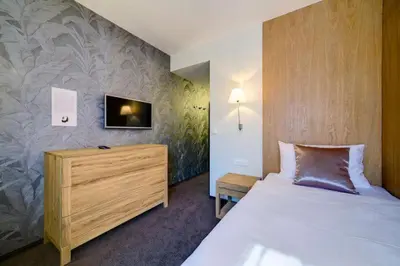 a bedroom with a bed and a tv on a wall at Hotel Restaurant Darwin in Prague