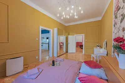 a living room with a table in the middle of a room at Colorful Wenceslas square apartment in Prague