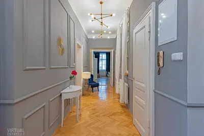 a hallway with a table and a chair at Colorful Wenceslas square apartment in Prague