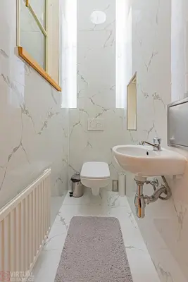 a white bathroom with a sink and a toilet at Colorful Wenceslas square apartment in Prague