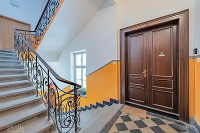 a hallway with a wooden door and stairs at Colorful Wenceslas square apartment in Prague