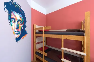 a room with two bunk beds and a wall with a mural at Hostel Elf in Prague