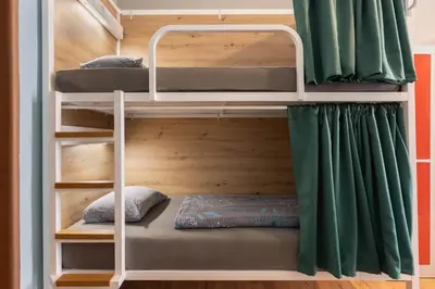 a bunk bed in a room with green curtains at Hostel Elf in Prague