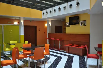 a restaurant with orange and yellow chairs and a table at City Central De Luxe in Prague