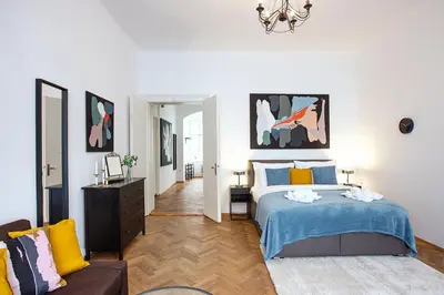 a white bedroom with a bed and a couch at 5BR 2BATH family APT 5mins to Wenceslas square in Prague