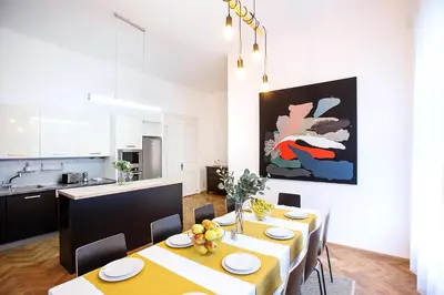 a dining room with a table with chairs and a kitchen at 5BR 2BATH family APT 5mins to Wenceslas square in Prague