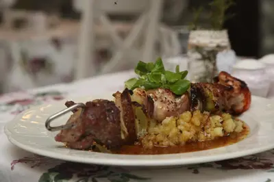 a plate of food with meat and vegetables on a table at Restaurace a pension Chalupa in Vorder Třebau