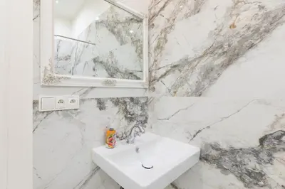 a white bathroom with a sink and a mirror at Lovely Apartments Heart of Prague in Prague