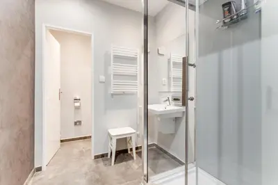 a bathroom with a glass shower and a sink at Lovely Apartments Heart of Prague in Prague