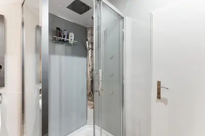 a shower with a glass door in a bathroom at Lovely Apartments Heart of Prague in Prague