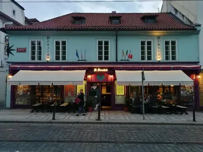 a building with people sitting outside of it at Apartments U Švejků in Prague