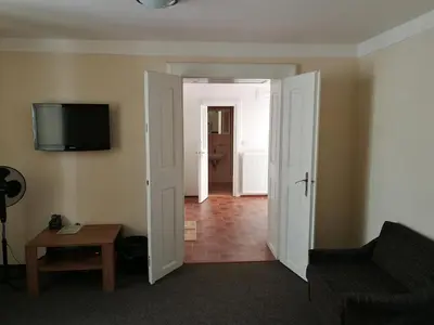 a living room with a couch and a tv on the wall at Apartments U Švejků in Prague