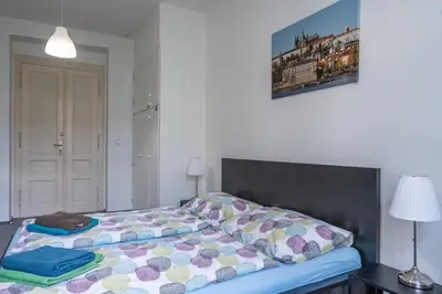 a bedroom with a bed and a picture on the wall at TopApartmany in Prague