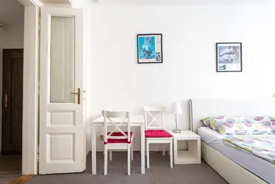 a bedroom with a bed and two chairs and a desk at TopApartmany in Prague