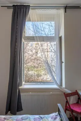 a bedroom with a window with curtains and a bed at TopApartmany in Prague