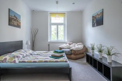 a bedroom with a bed and a chair at TopApartmany in Prague