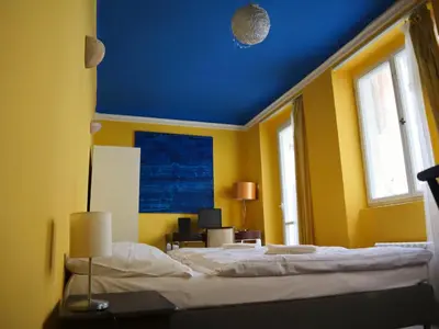 a bedroom with a bed with a blue ceiling at Charles Bridge Hostel & Apartments in Prague